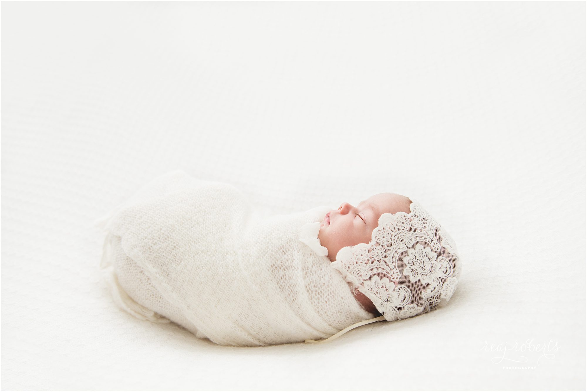 Newborn photos baby wrapped in white backlit | © Reaj Roberts Photography | Chandler, Arizona