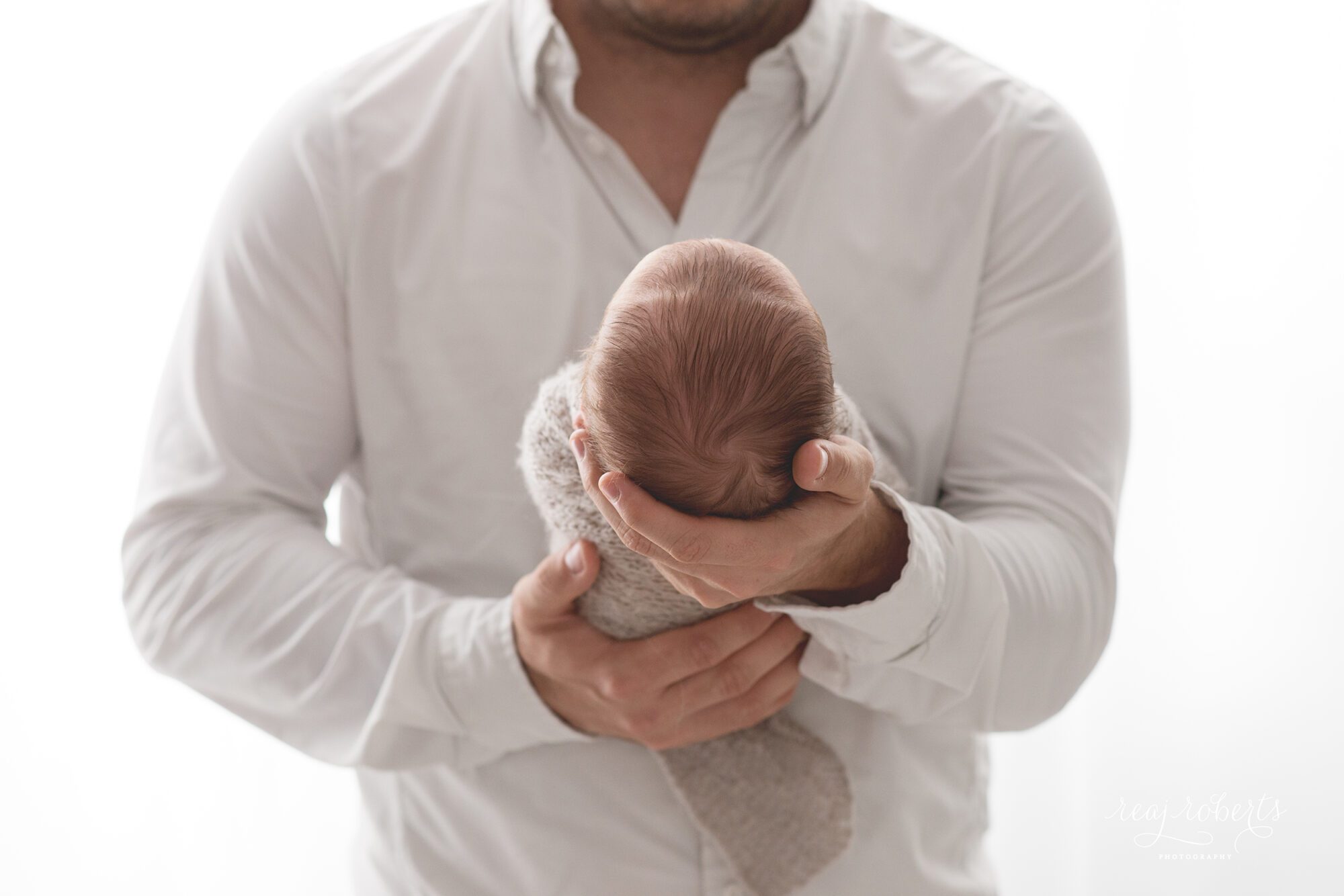 Newborn in dad's hands backlit photography | Chandler, AZ | Reaj Roberts Photography