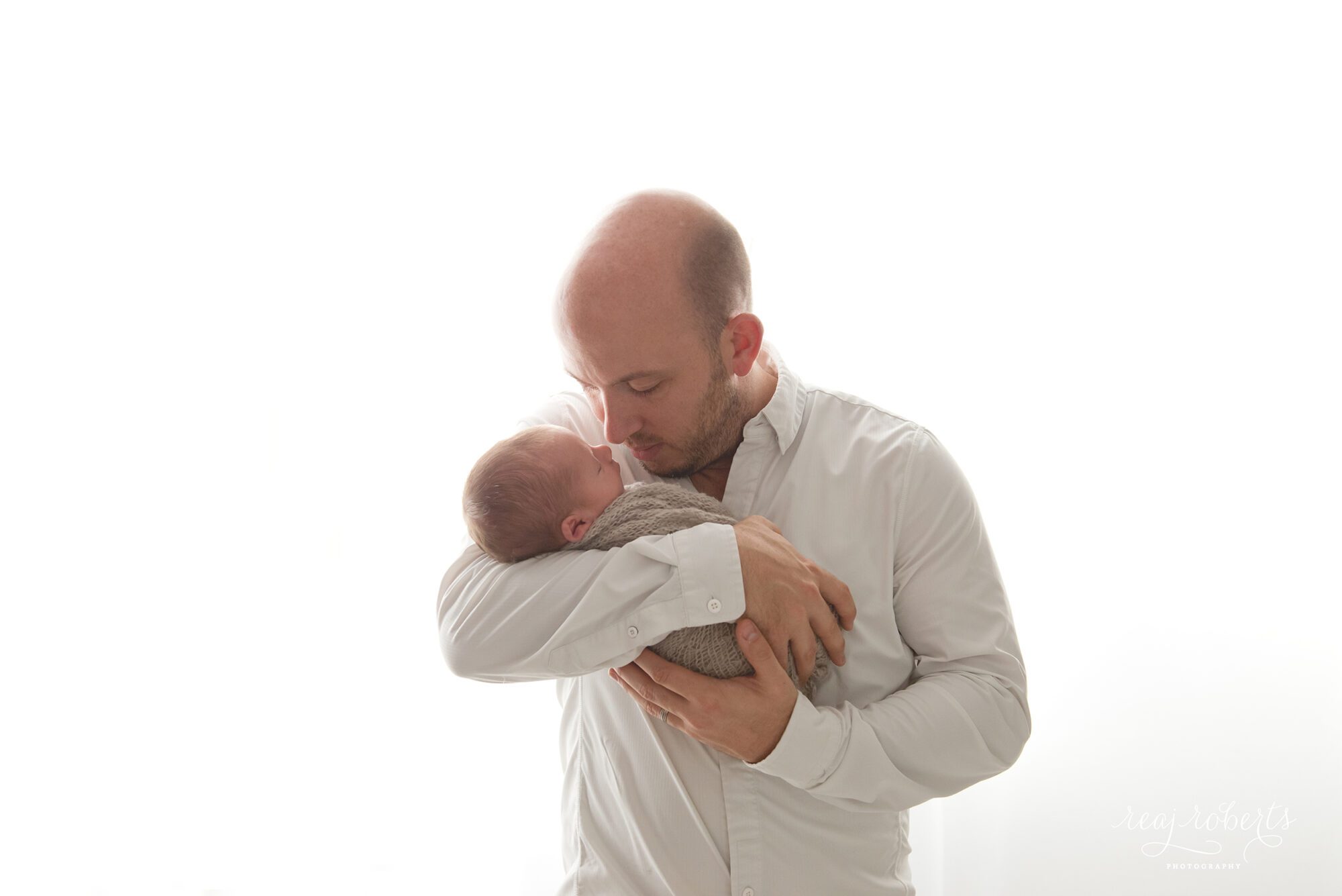 Newborn with father backlit photography | Chandler, AZ Newborn Photographer | Reaj Roberts Photography