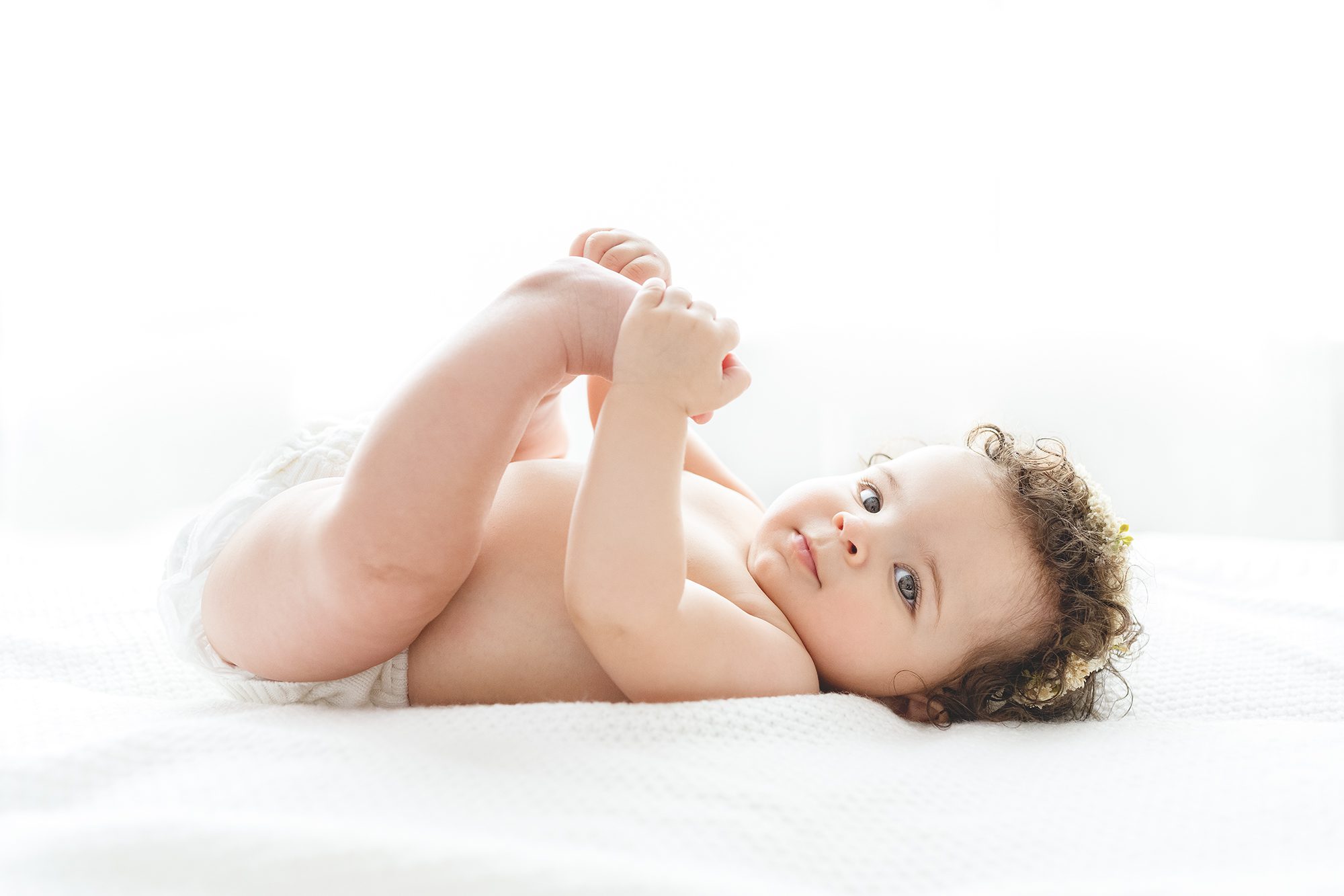 baby girl curling her legs forward | 6 month baby girl by Reaj Roberts Photography