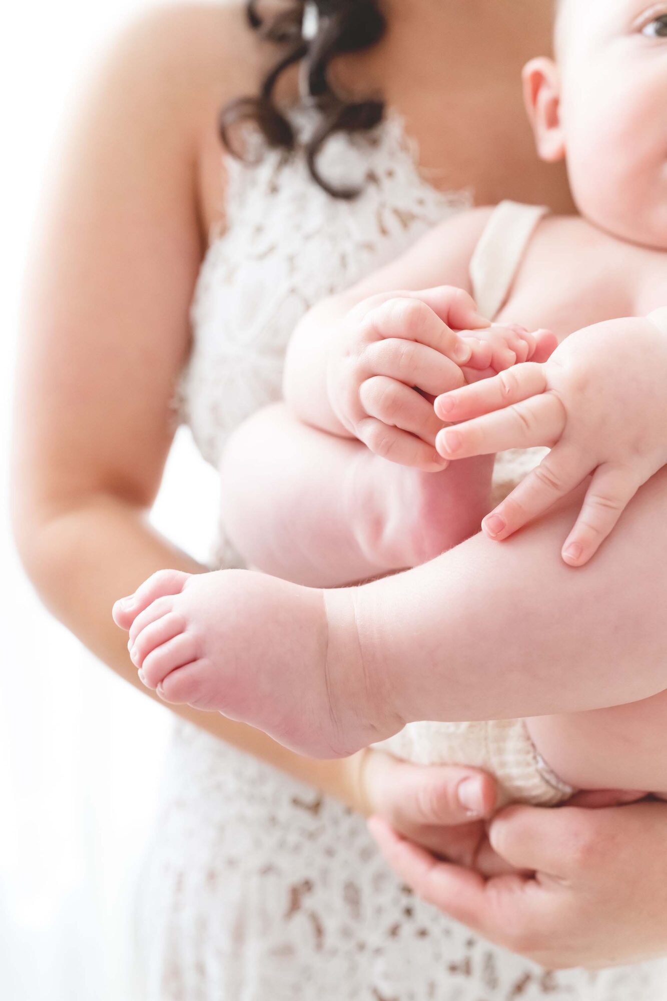 Reaj Roberts Photography baby held in mother's arms squishy hands and feet details