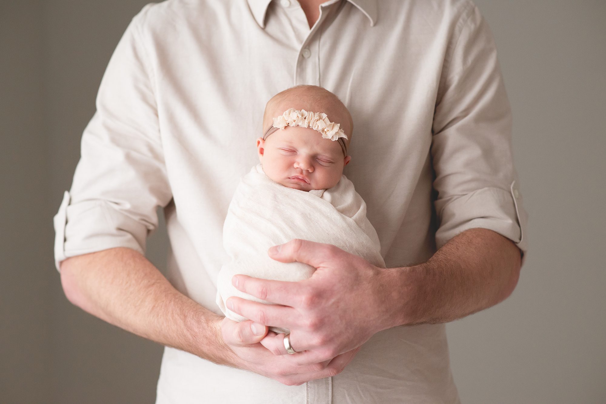 newborn baby girl swaddled wrapped in dad's arms Chandler newborn photographer