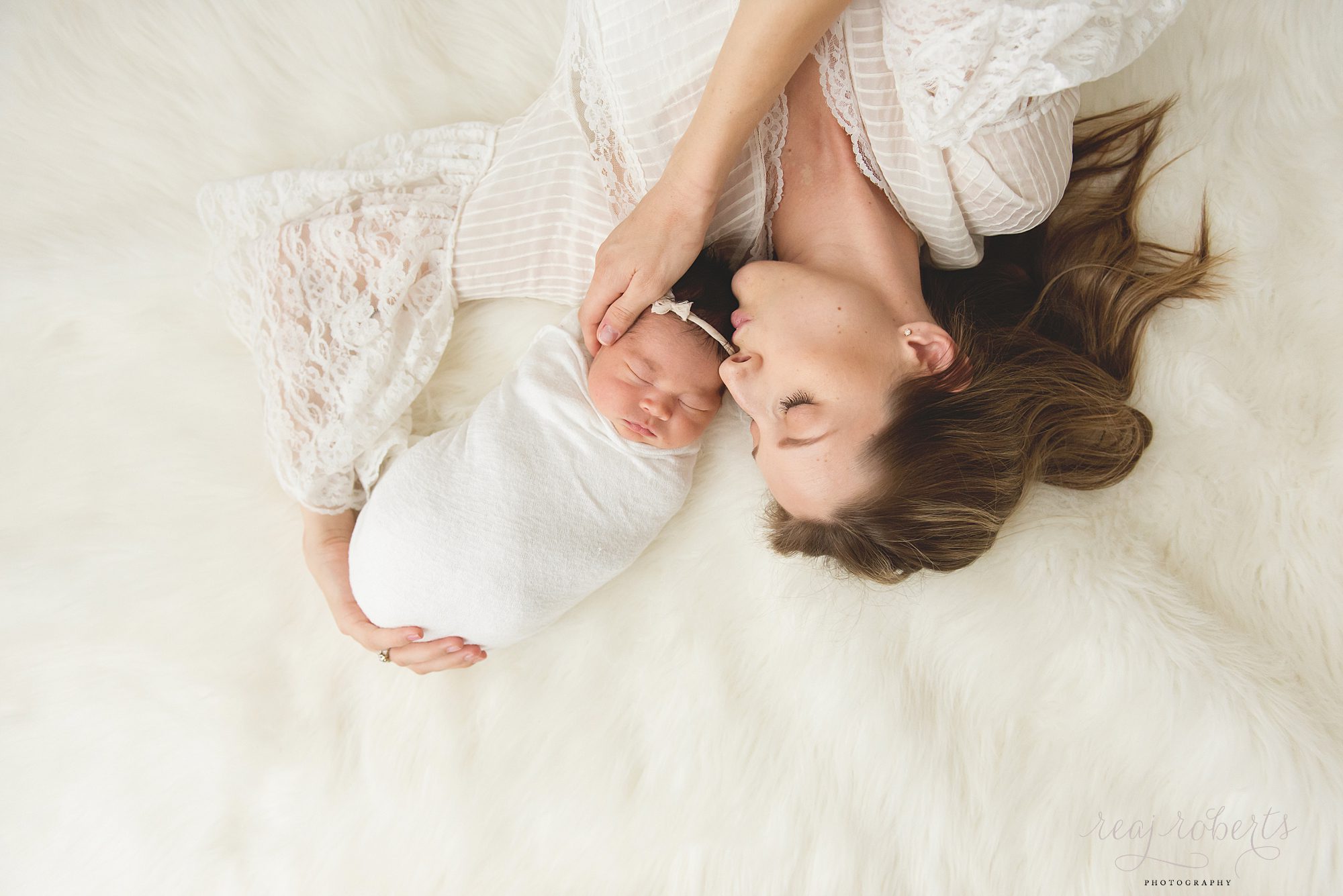 Chandler Baby Photographer | Reaj Roberts Photography | mother laying down kissing newborn on head