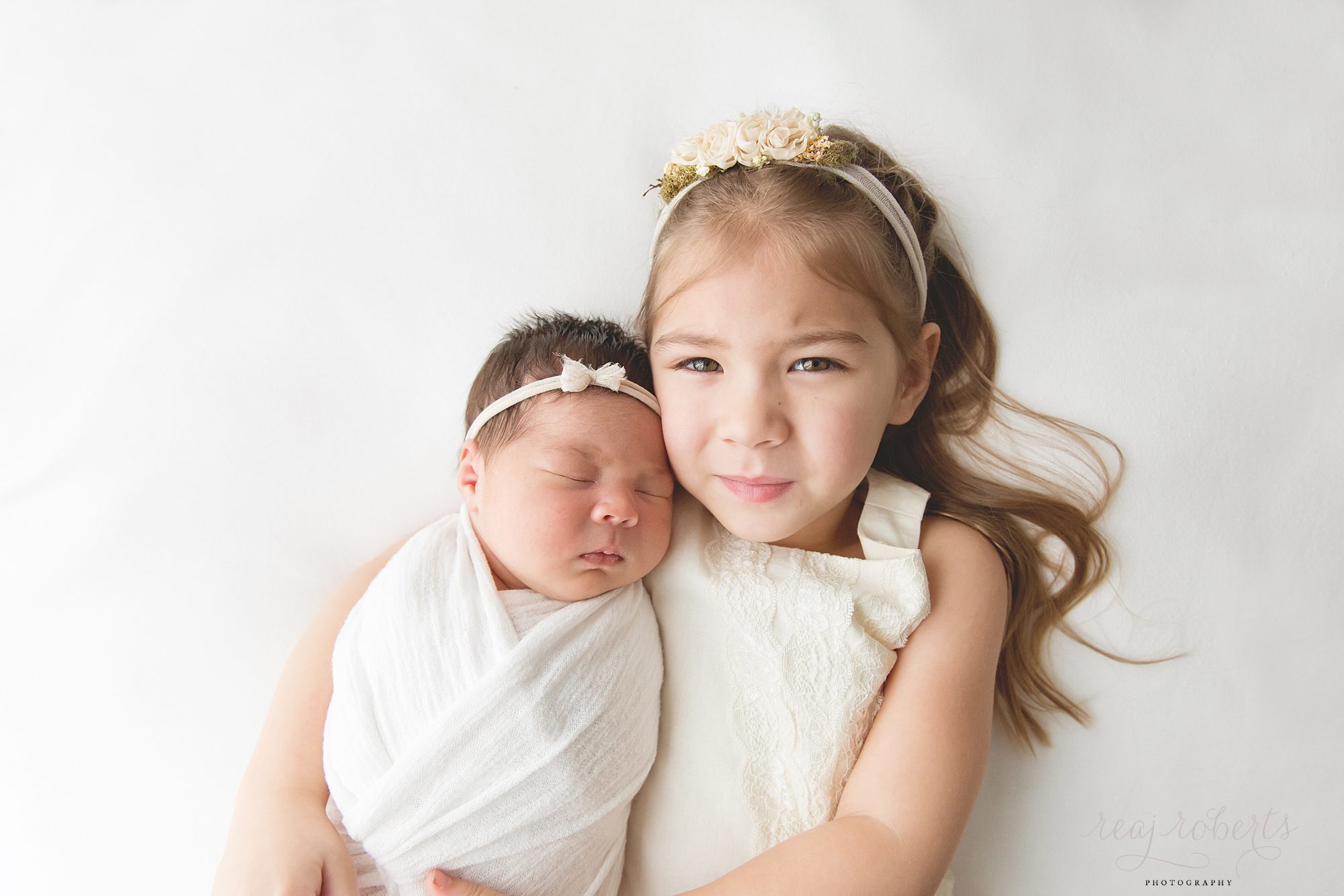 Chandler Baby Photographer | Reaj Roberts Photography | newborn with older sister laying down pose