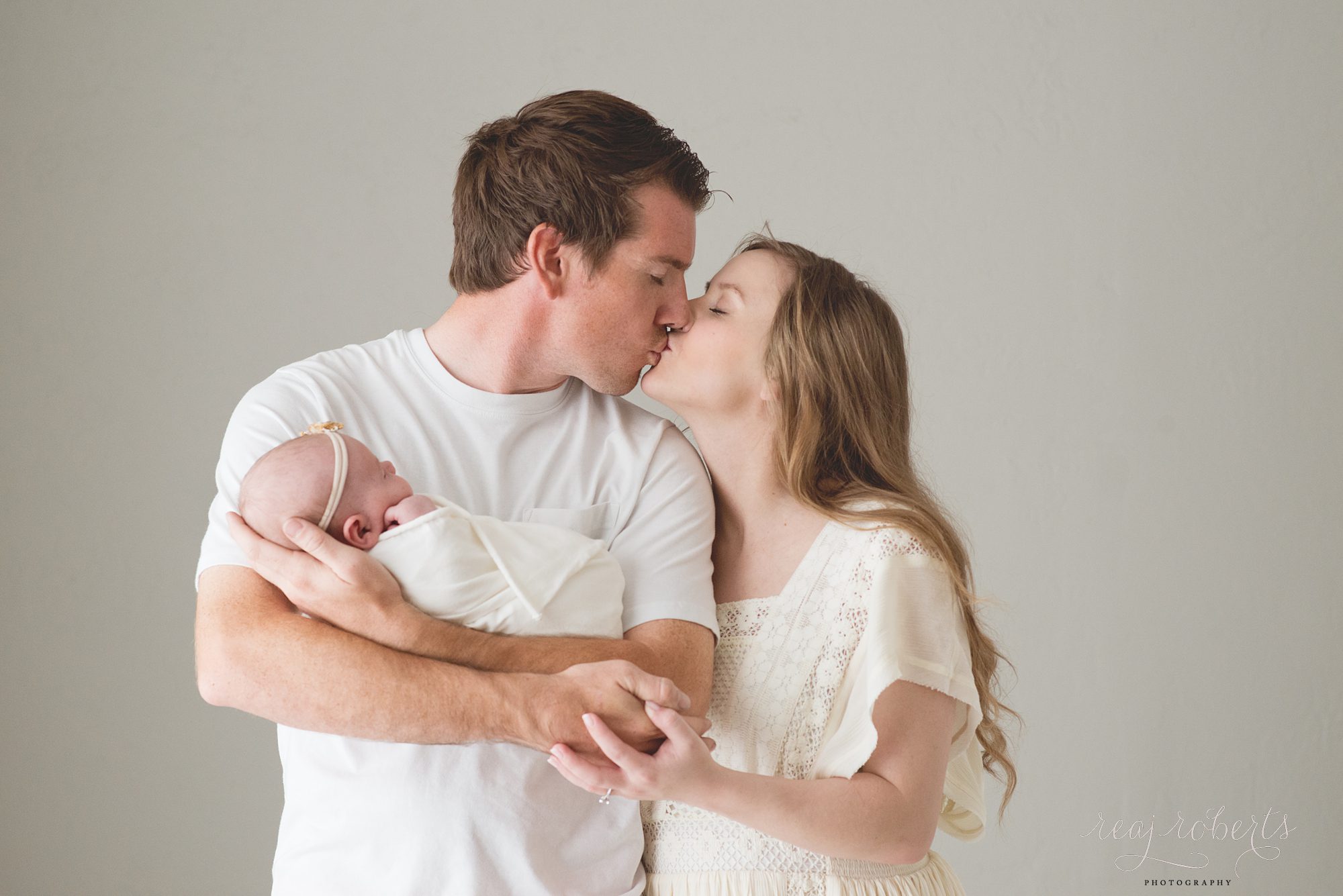 Family posing with newborn baby | Reaj Roberts Photography