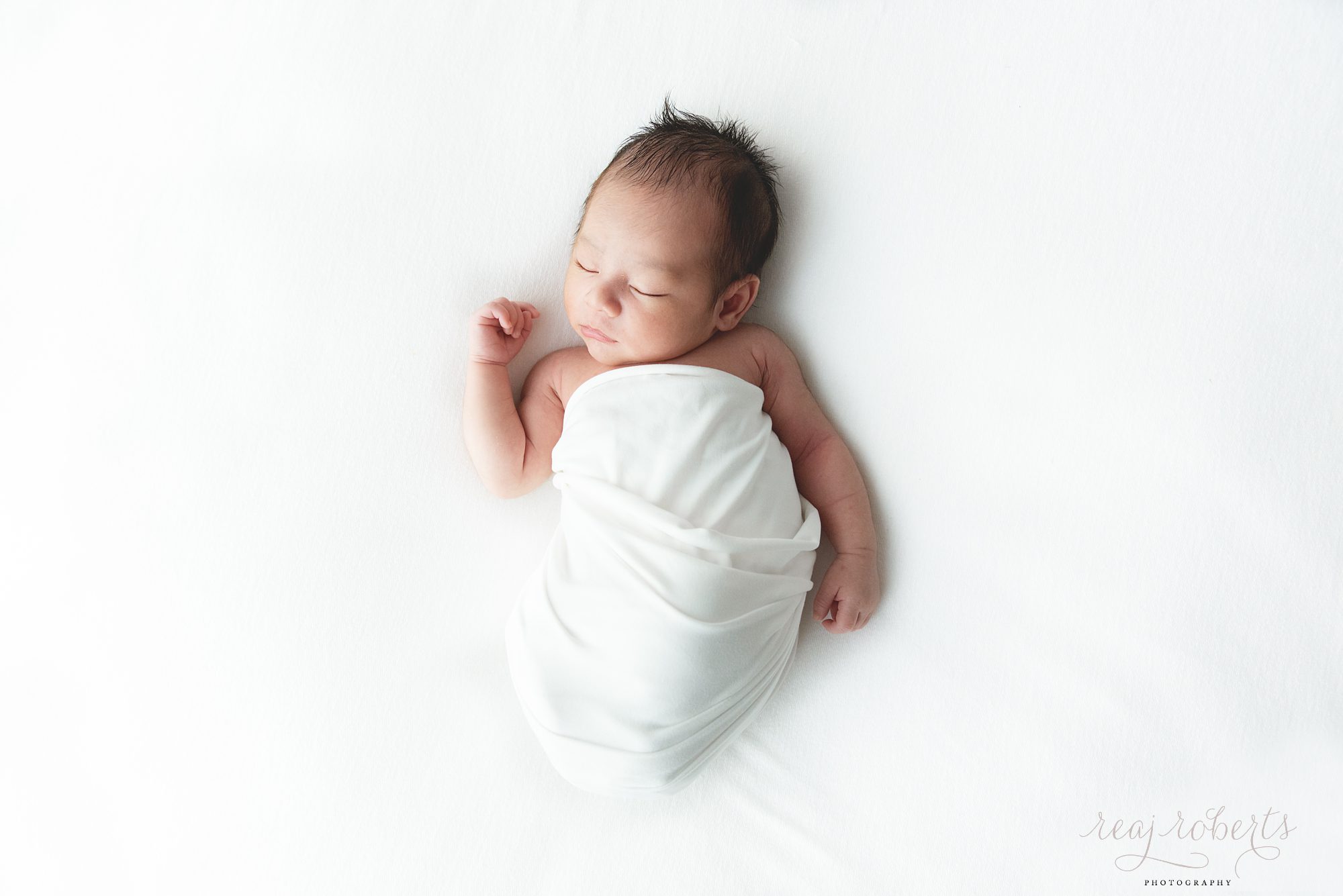 clean natural neutral newborn photographer simple baby posing baby on back swaddled | Reaj Roberts Photography