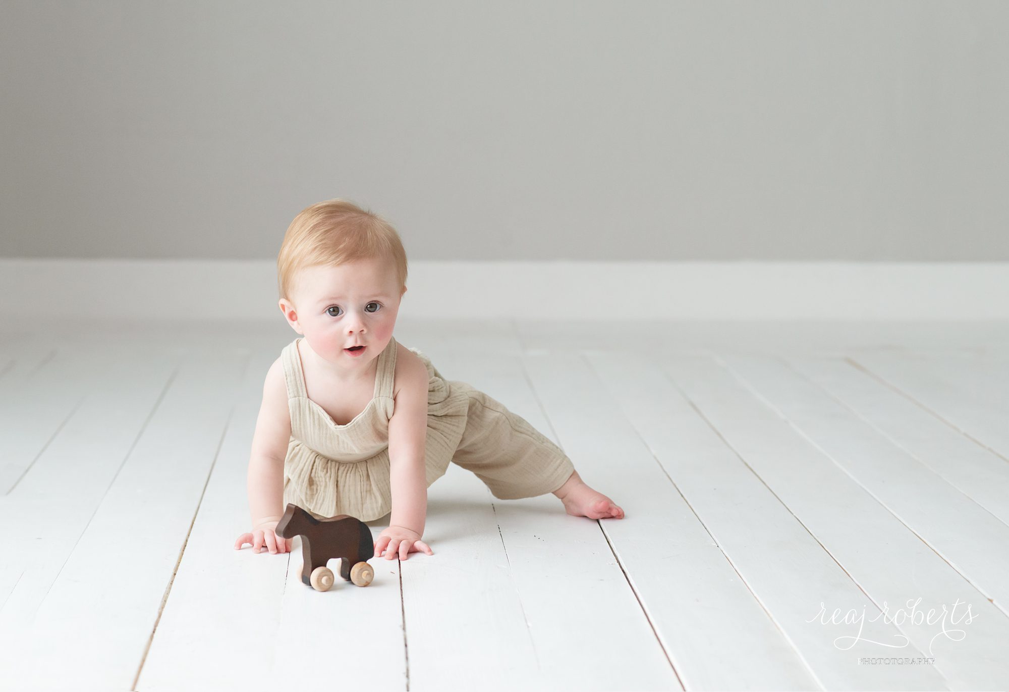 Chandler baby milestone photographer 6 month photo session girl with wooden horse & linen romper | Chandler Family Photographer | Reaj Roberts Photography