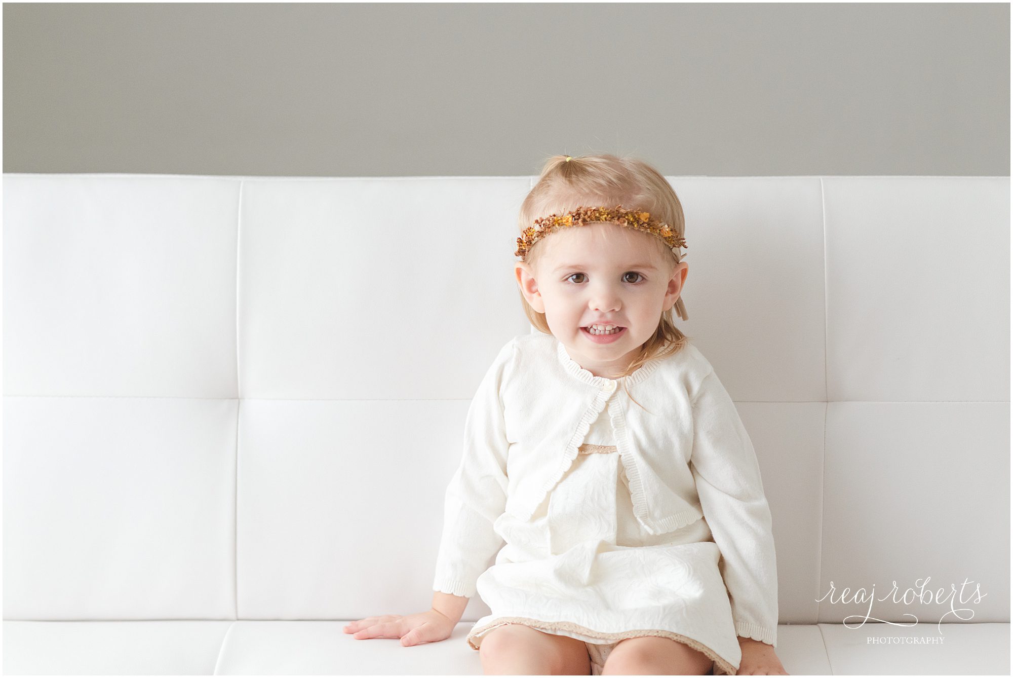 2 year old toddler girl wearing dried flower crown and white dress and sweater set by Reaj Roberts Photography