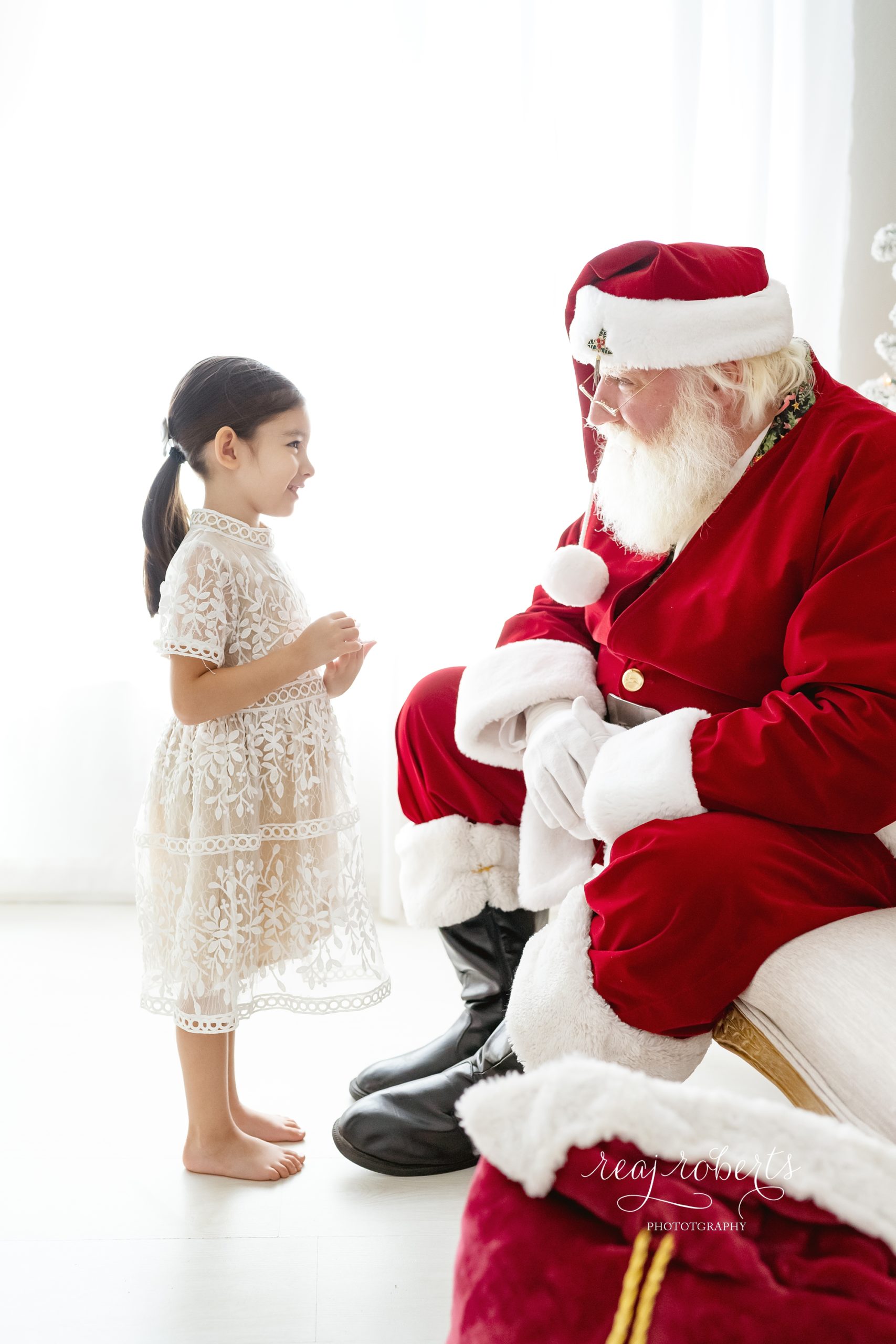© Reaj Roberts Photography Scottsdale Arizona Photos with Santa girl talking with Santa backlit