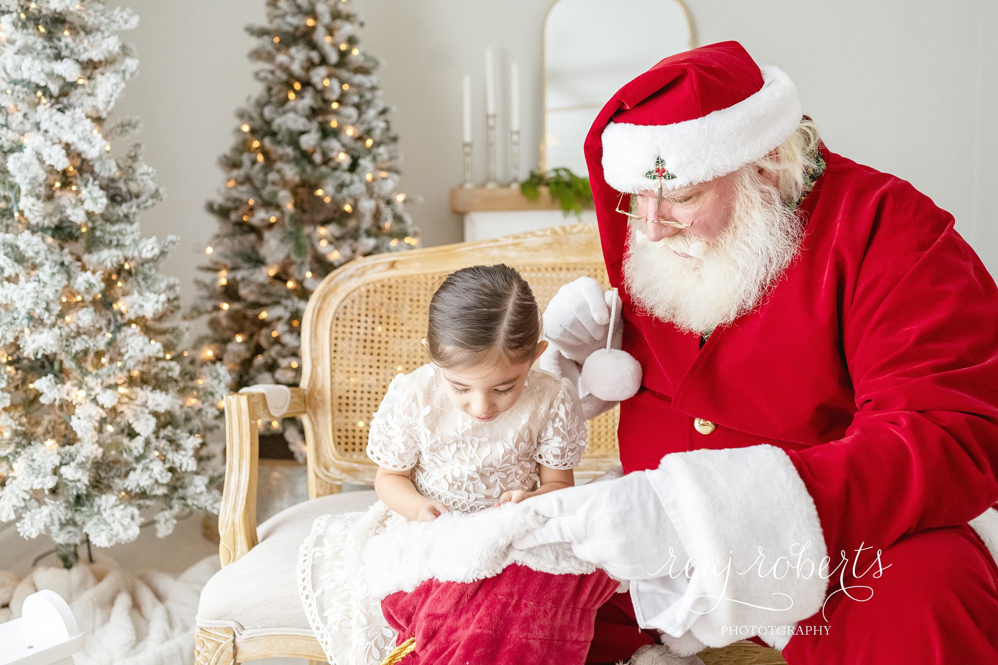 © Reaj Roberts Photography Scottsdale Arizona Photos with Santa girl peeking into Santa's sack