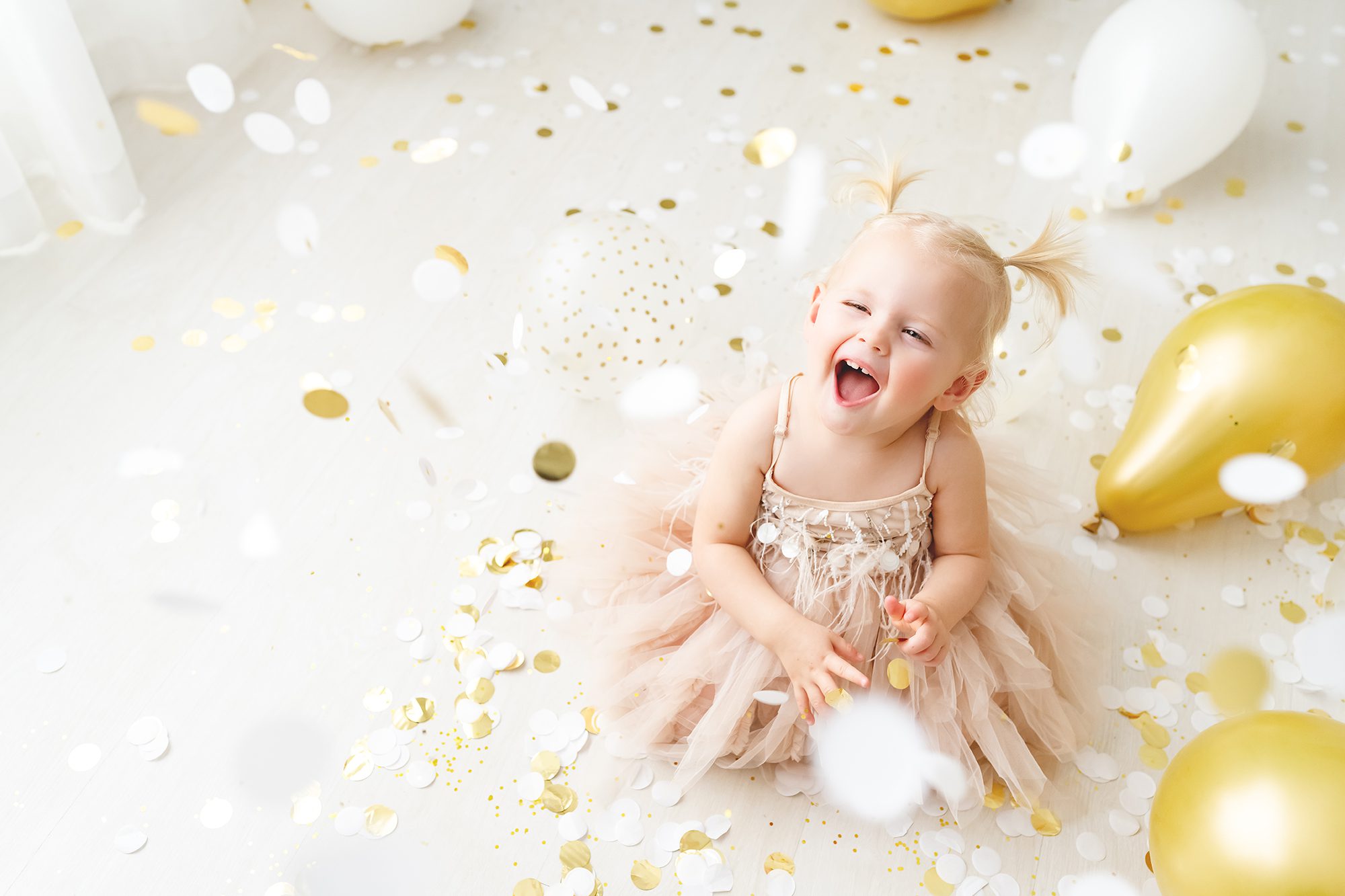 new years eve photoshoot ideas kids baby girl in blush pink dress with gold confetti and gold balloons